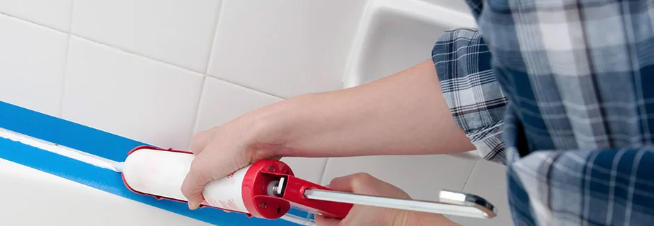 Person trägt Dichtmittel mit Kartuschenpistole auf